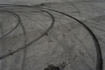 Asphalt texture with white line and tire marks. Smooth asphalt road. Tarmac dark grey grainy road...