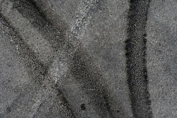Asphalt texture with white line and tire marks. Smooth asphalt road. Tarmac dark grey grainy road background.Top view - 502098367