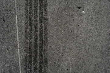 Asphalt texture with white line and tire marks. Smooth asphalt road. Tarmac dark grey grainy road background.Top view - 502098543