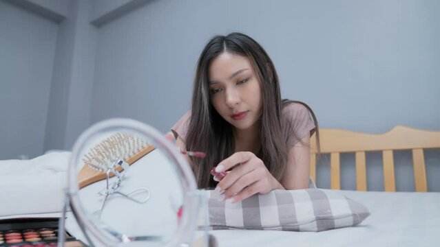 Beauty concept of 4k Resolution. Asian girls make makeup on the bed in the bedroom.