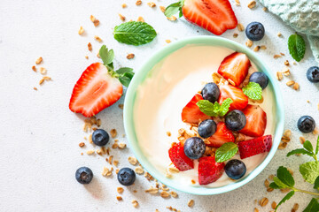 Greek Yogurt with granola and fresh berry mix at white stone table. Top view with copy space.
