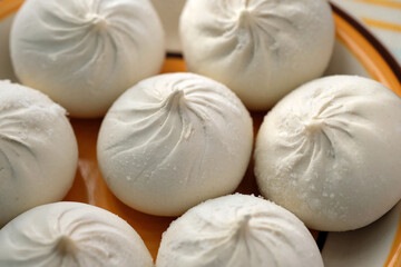 Frozen khinkali on a plate close-up. Raw khinkali stuffed with meat. Dough and meat product. Frozen semi-finished products.