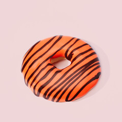 Orange donut on pink pastel background