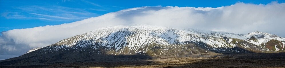 Obraz premium View during auto trip in West Iceland highlands, Snaefellsnes peninsula, Snaefellsjokull Volcano. Spectacular volcanic tundra landscape with mountains in clouds.