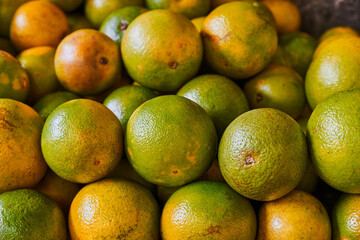 Yellow oranges placed on a shelf for sale within a market