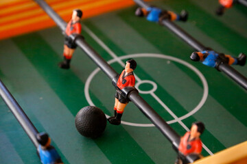 Fototapeta premium Foosball. Soccer hall game. Traditional game. Soccer game. Table with soccer players. Old wooden foosball. Football players. Dolls with blue and red painted T-shirts. Metegol