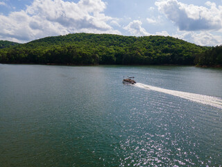 Pontoon boat traveling at full throttle across open lake. Party barge on Lake Altoona during the...