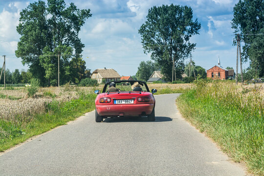 Wiaczemin Polski, Poland - August 12, 2021. Retro vintage red convertible car on small road between villages
