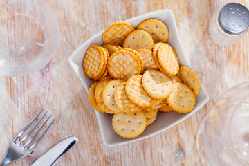 Delicious crackers in a plate on a wooden table. Close-up image