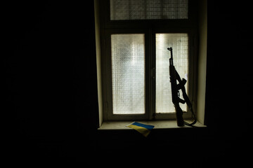 Conceptual photo of war between Russia and Ukraine. Ukraine and Russia flags on windowsill at...