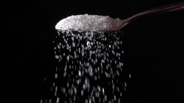 pouring sugar from a spoon, slow motion 10x