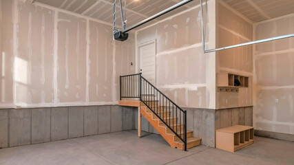 Panorama Interior of an unfinished garage with staircase leading to the door