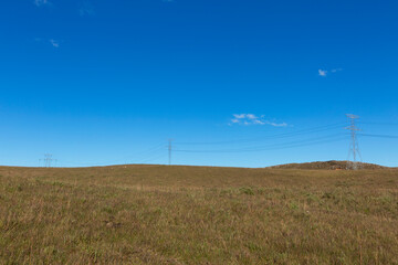Fototapeta na wymiar Electric power tower in the countryside, blue sky background.