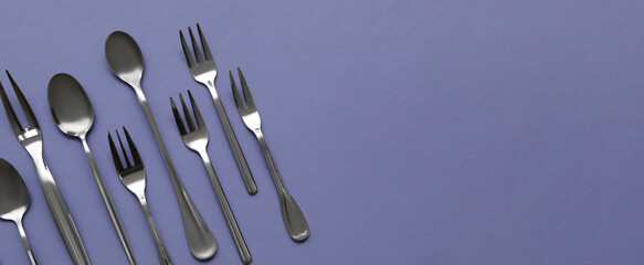 Many different cutlery on color background with space for text