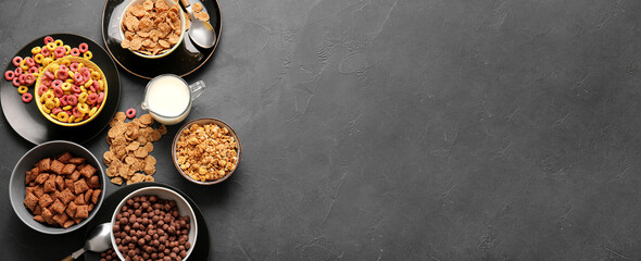 Collection of tasty breakfast cereals with milk on dark background with space for text
