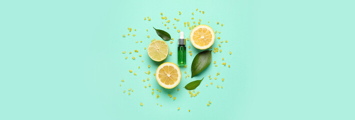 Obraz na płótnie Canvas Bottle of natural serum, green leaves, lemon, lime and sea salt on turquoise background. Banner for design
