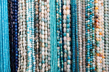 Beads from various gemstones on the showcase of a jewelry store