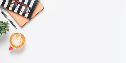 Office desk with eyeglass, Pen, notebook, Cup of coffee on white background, Top view with copy space, Mock up..