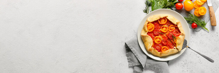 Plate with tasty tomato galette on light background with space for text