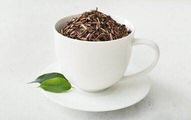 Cup with green hojicha tea on light background