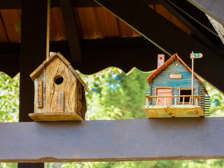 Two bird houses up on the roof of a country house
