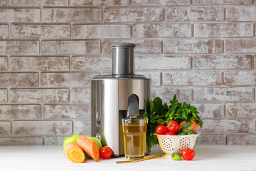 New modern juicer and glass of fresh juice on table