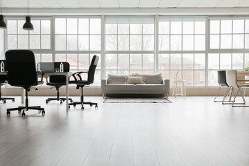 Interior of light office with sofa, table and chairs
