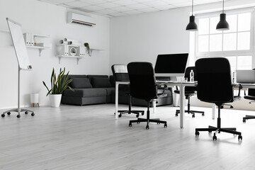 Interior of modern office with table, chairs and sofa