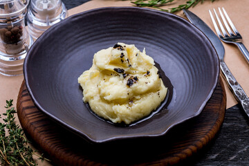 mashed potatoes on black bowl with black truffle - 502122714
