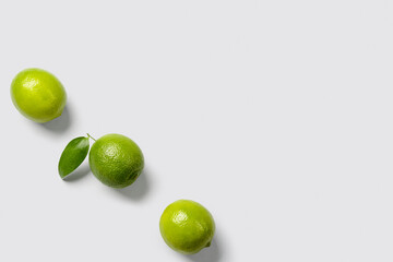 Fresh juicy limes on light background