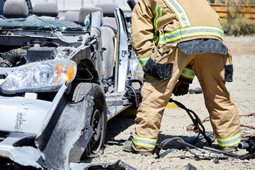 Fire Fighters using the Jaws of Life to dismantle a car