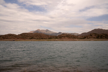 Fototapeta premium View of the reservoir in Potrerillos, Mendoza. The arid environment, turquoise glacier water lake and Andes mountains in the background.
