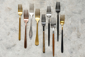 Many different forks on light background, top view