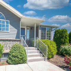 Square White puffy clouds Facade of a house with shrubs, trees and lawn at the front