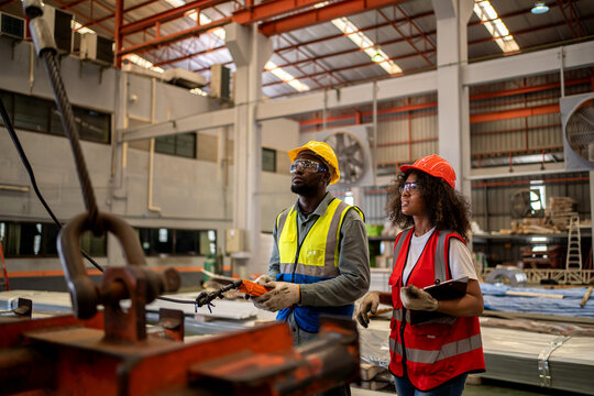 Industrial factory and manufacturing concept. Engineering with technician working with crane.