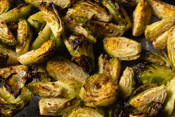 Brussels sprouts roasted in the oven with spices, salt, black pepper and Italian herbs in a glass tray.  Vegetarian home cooking concept.