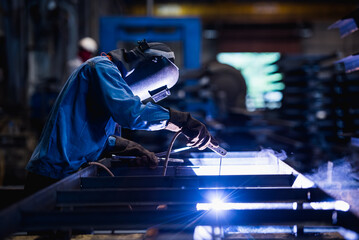 Industrial welder welding fabricated construction in factory, Welding process by Shielded Metal Arc...