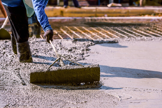 Concrete pouring process. Construction workers are pouring concrete in civil building foundation at the construction site.