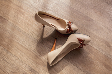 Pair of shoes on wooden background. Women's beige high-heeled shoes.