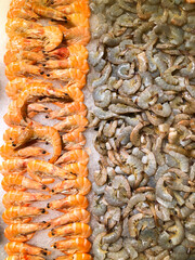 Raw peeled and unpeeled shrimps in ice