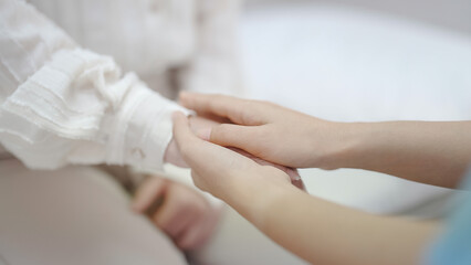 Hand of female doctor comforting patient at consulting room. Woman doctor and patient are discussing consultation about symptom problem diagnosis of disease
