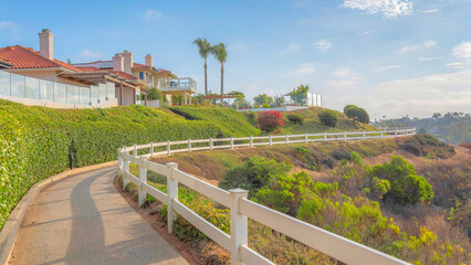 Panorama White puffy clouds Concrete trail with white wooden railings at Southern California
