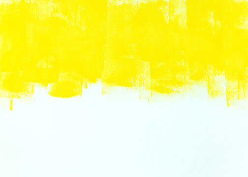 white wall partially painted in yellow color with paint roller