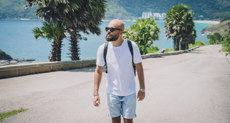 Young traveler man at summer holiday vacation with beautiful palms and seascapes at background