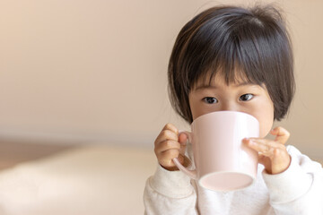コップでお茶を飲む赤ちゃん(1歳9ヶ月、女の子、日本人)