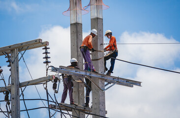 Electricians is repairing high voltage wires on electric power pole