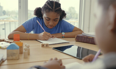 Student in international preschool writing a book together in Elementary School Class, Pupils enjoying studying in classroom.