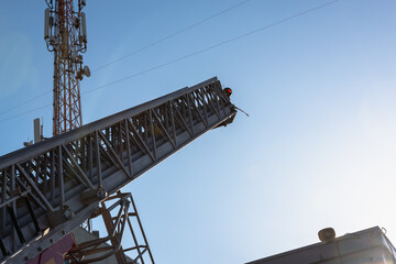 The fire engine pushes the ladder to extinguish the fire on the roof of the building.