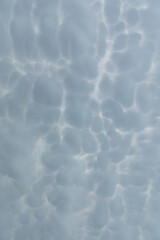 A wide patch of sky strewn with storm clouds in the shape of bubbles.