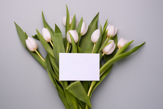Greeting card mockup with white tulips background